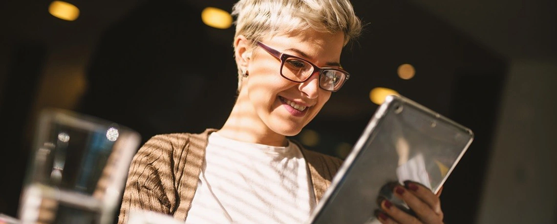 Frau liest die digitale Tageszeitung auf ihrem Tablet